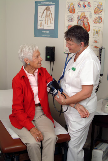 A nurse takes the blood pressure of an elderly patient during a medical examination.