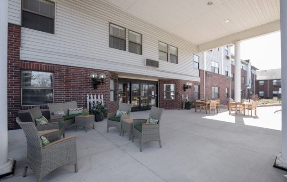 Outdoor seating area in front of a brick building with entrance.