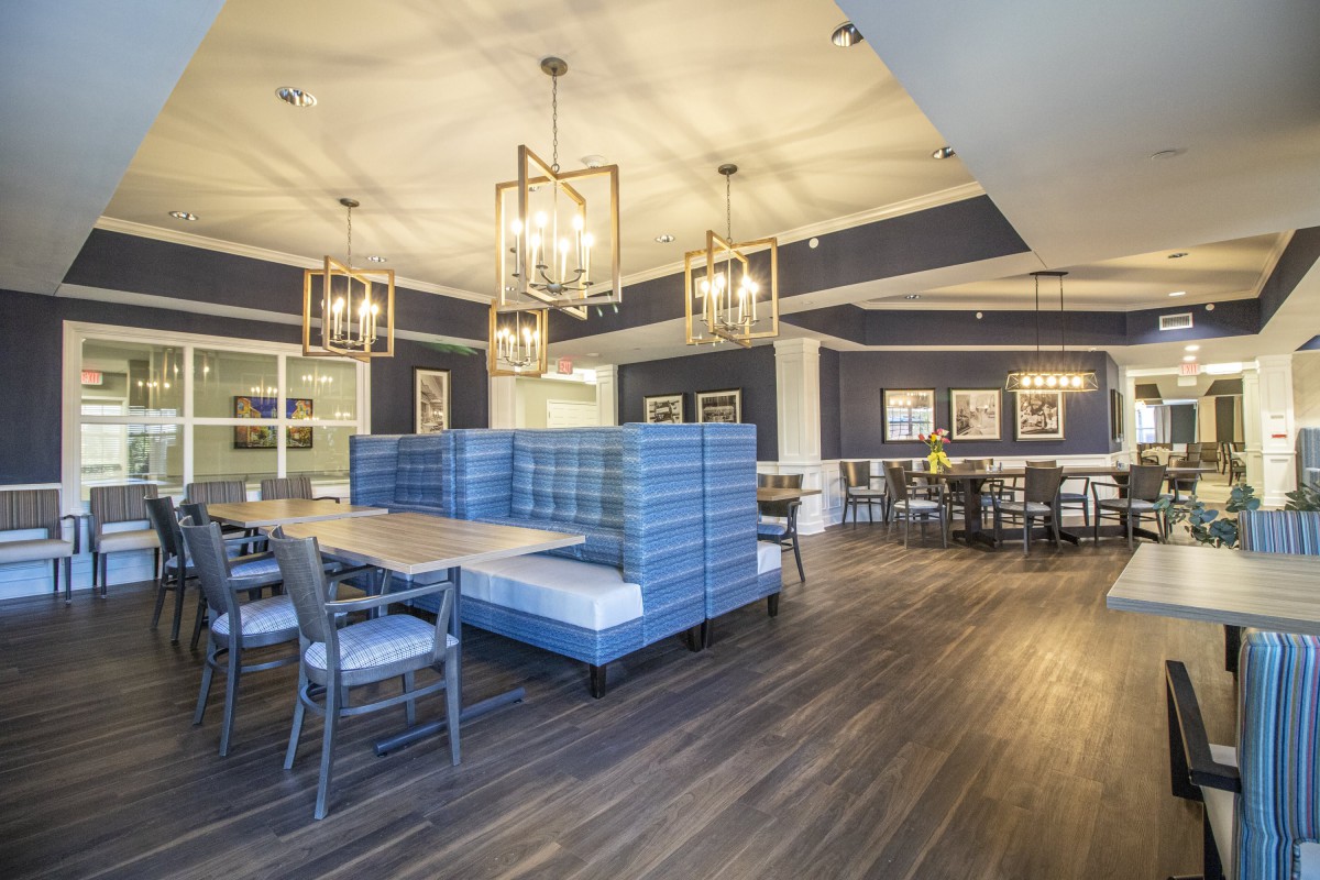 A modern dining area featuring stylish blue upholstery and elegant lighting.