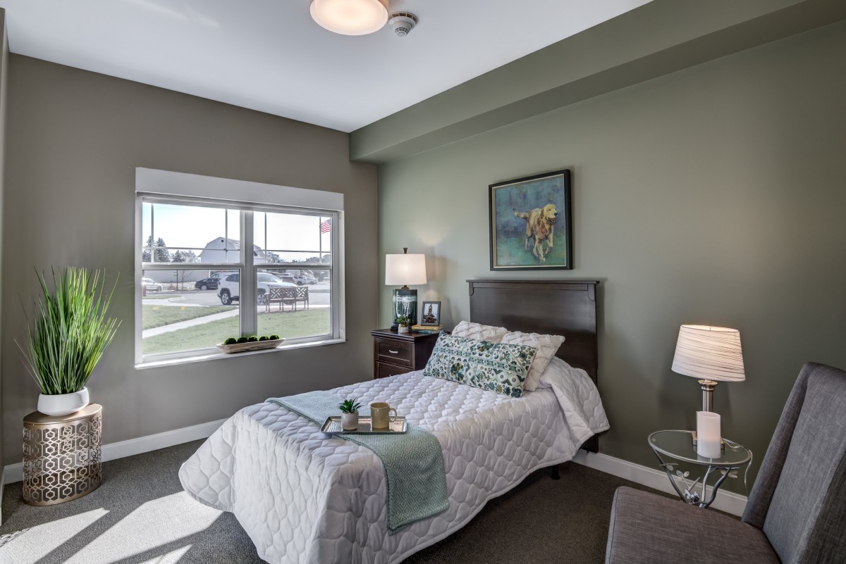 A cozy bedroom with a large window, modern decor, and neutral color palette.