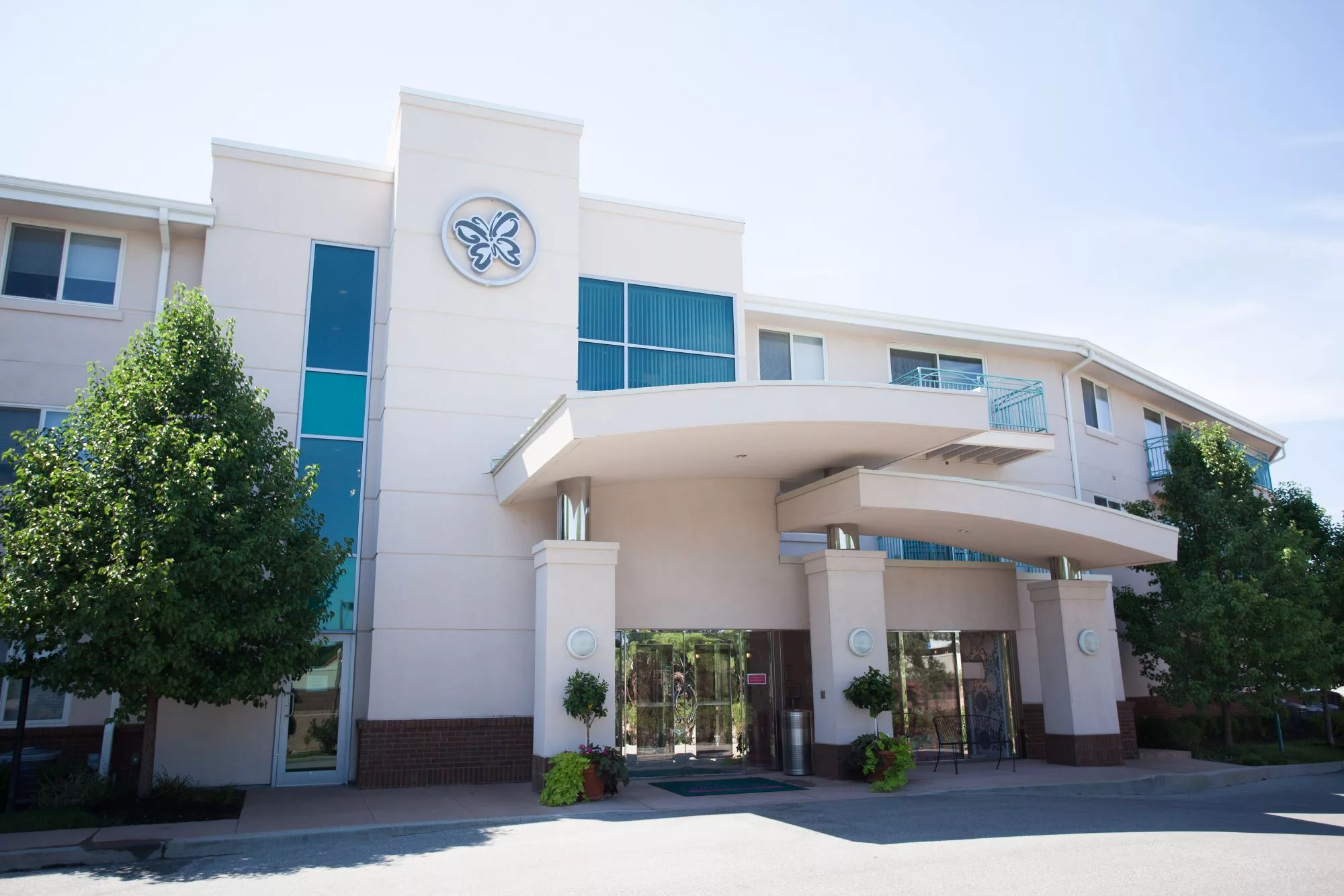 A modern building with large windows and a prominent entrance on a sunny day.