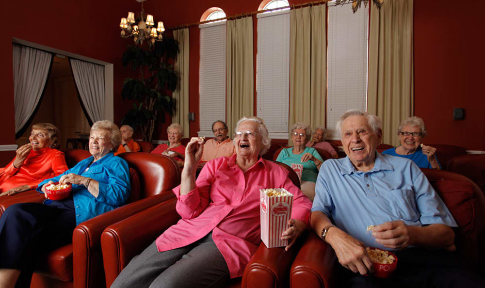 A group of elderly people enjoying a movie together in a cozy theater setting.