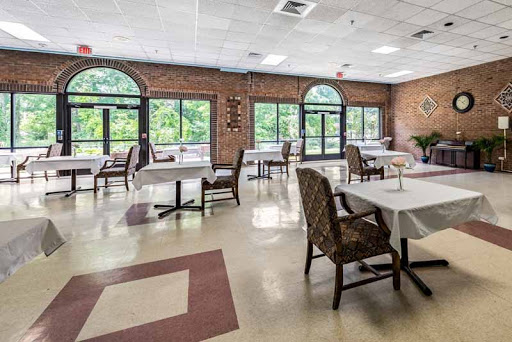 A spacious and inviting dining area featuring tables and chairs with ample natural light coming through large windows.