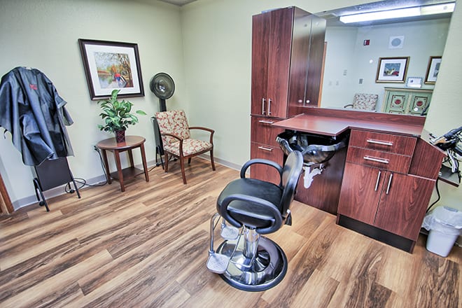 A modern hair salon interior with a barber chair, stylish cabinets, and decor elements.