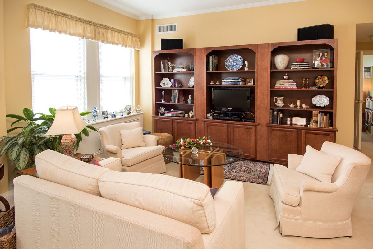 A cozy living room with comfortable seating, a wooden entertainment center, and tasteful decor.