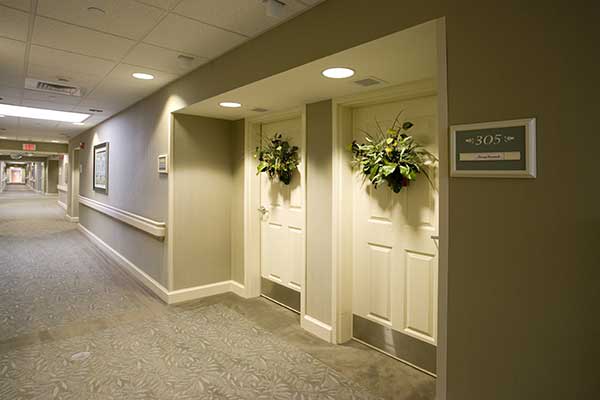A hallway with two decorated doors adorned with plant arrangements.