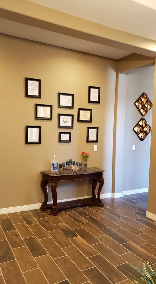 A hallway featuring a console table with decorative items and an arrangement of picture frames on the wall.