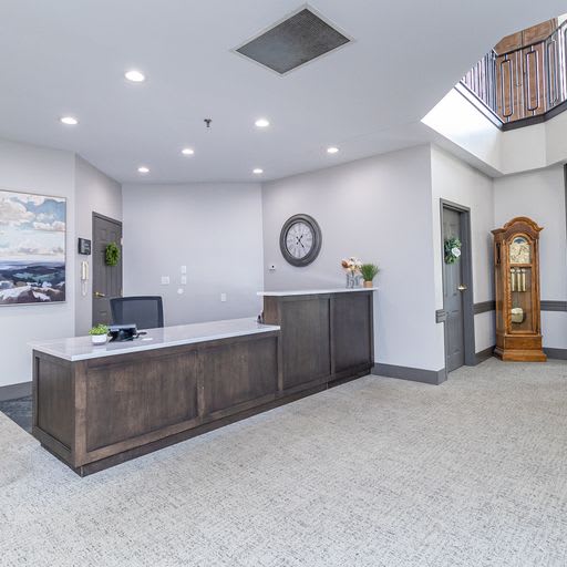 A modern reception area with a wooden desk and white walls.