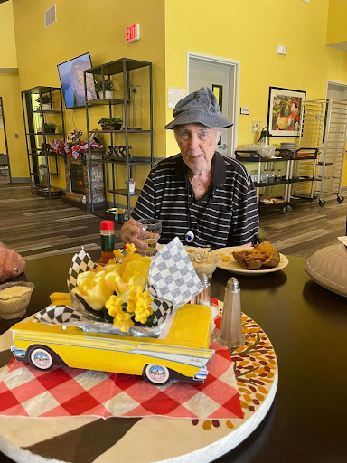 An elderly individual enjoying a meal in a vibrant dining area, celebrating with festive decorations.