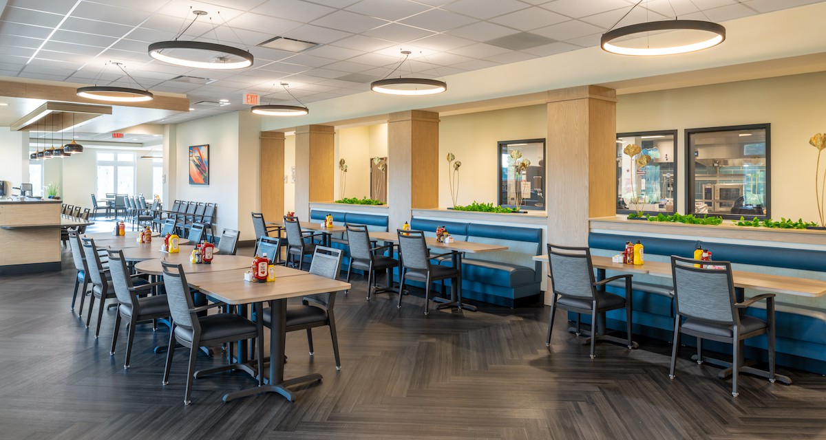 A modern dining area with tables and chairs in a restaurant setting.