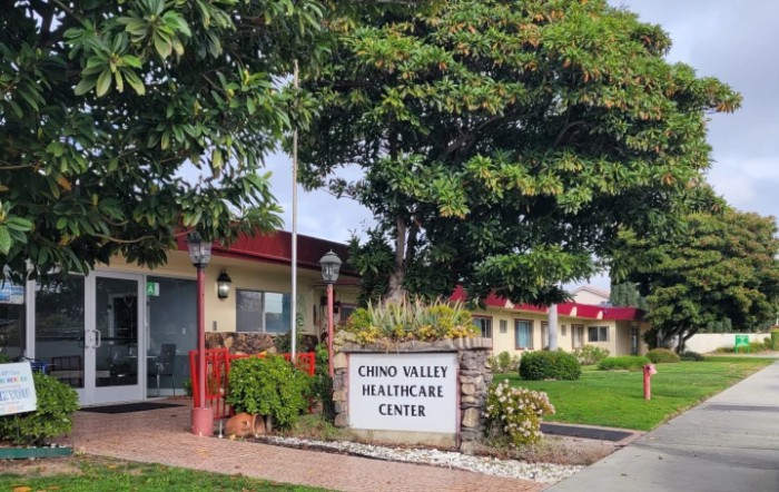 The exterior of Chino Valley Healthcare Center surrounded by trees and plants.