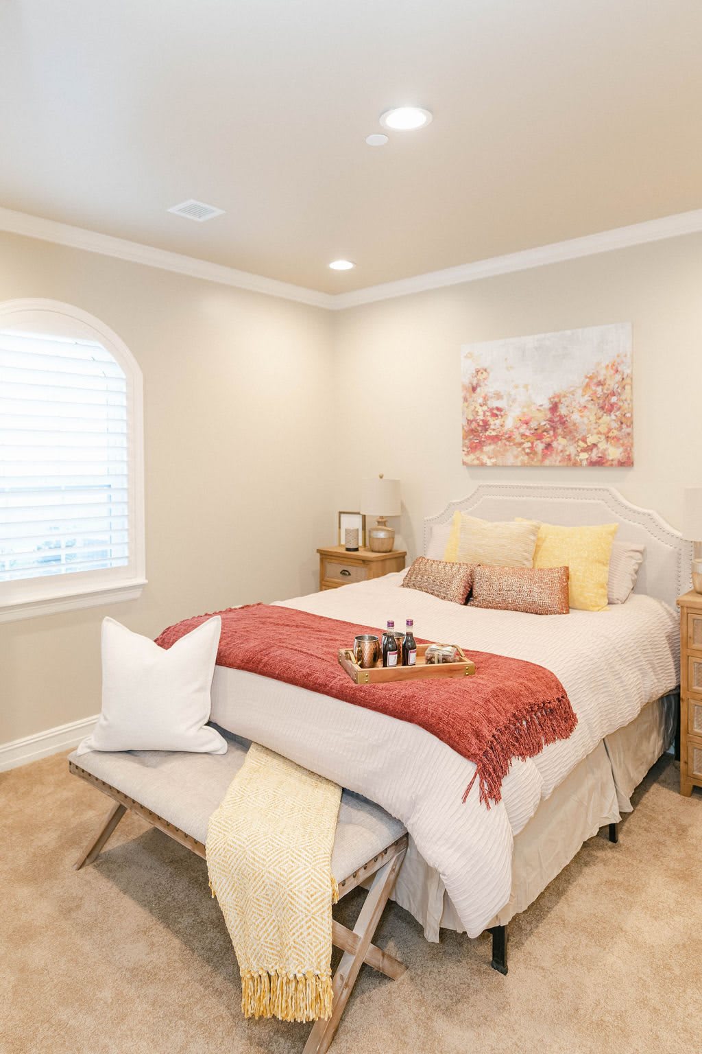 A cozy and well-decorated bedroom with warm tones and comfortable bedding.