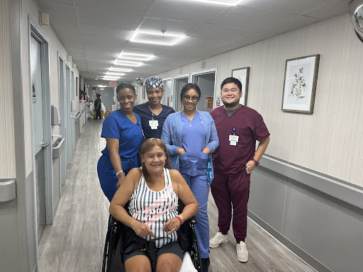 Healthcare team assisting a patient in a hospital corridor.