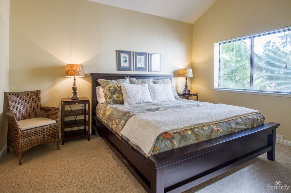 A cozy bedroom with a large bed, decorative pillows, and side lamps.