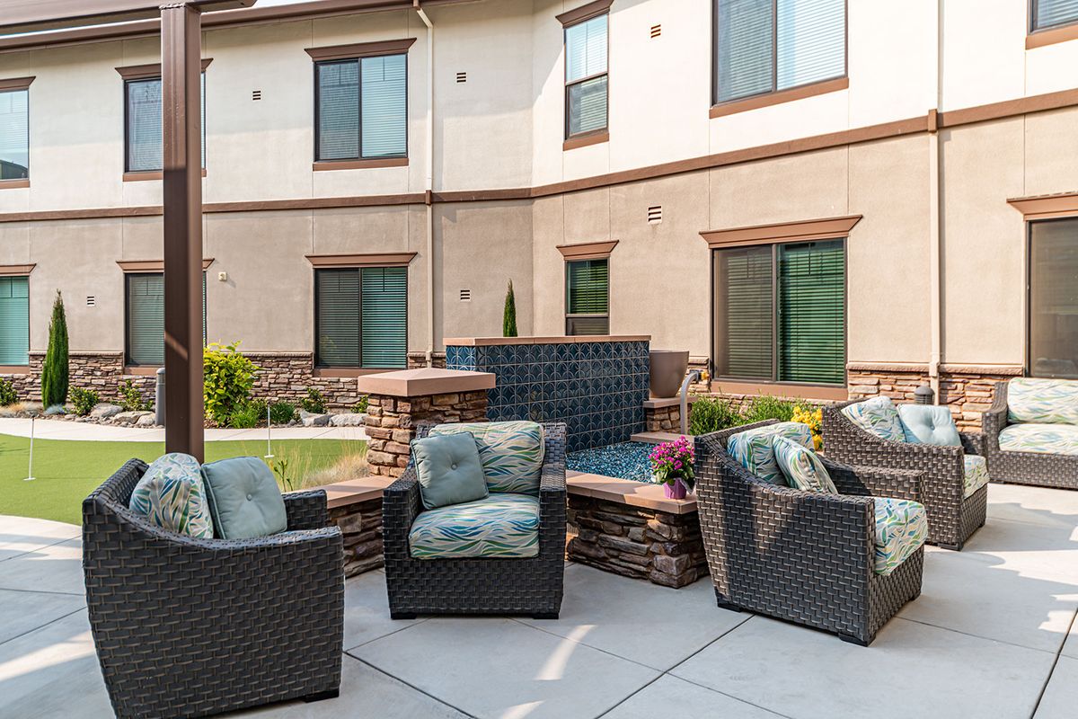 Patio seating area with wicker chairs in a courtyard setting.