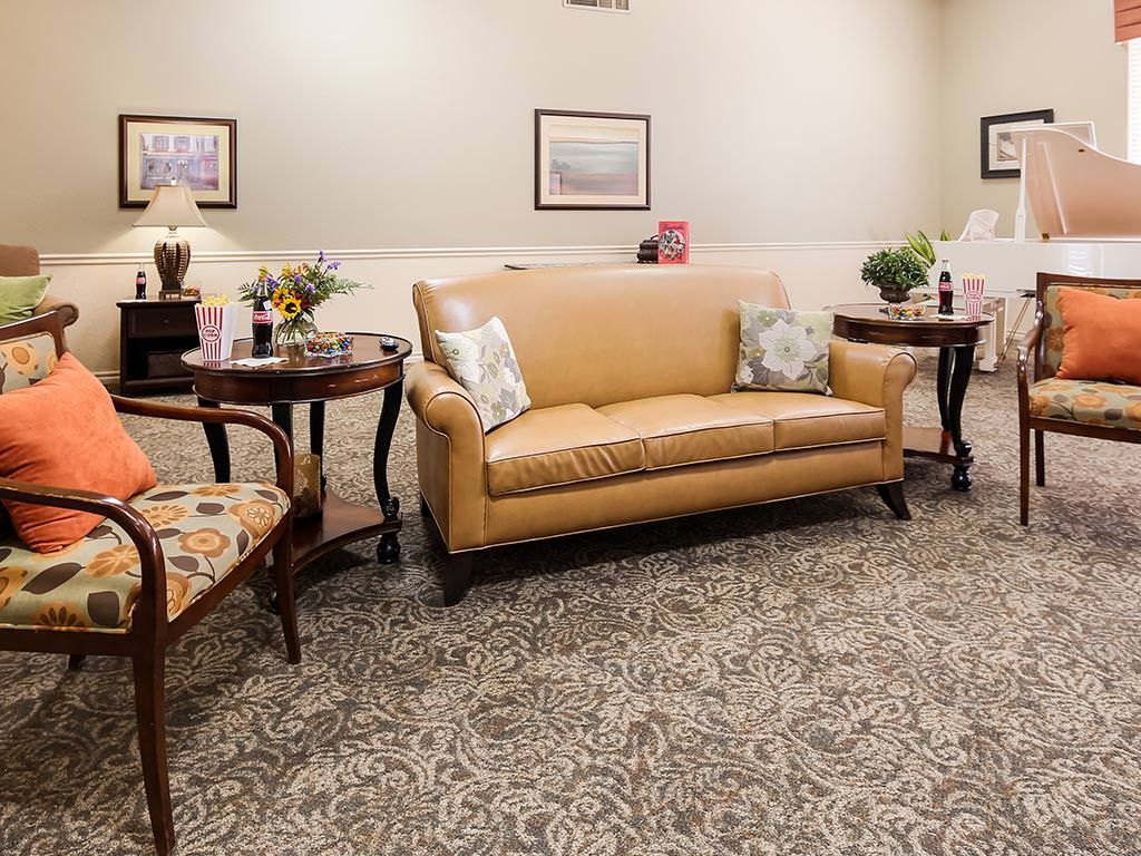 A cozy living room with a tan sofa, patterned carpet, and elegant decor.