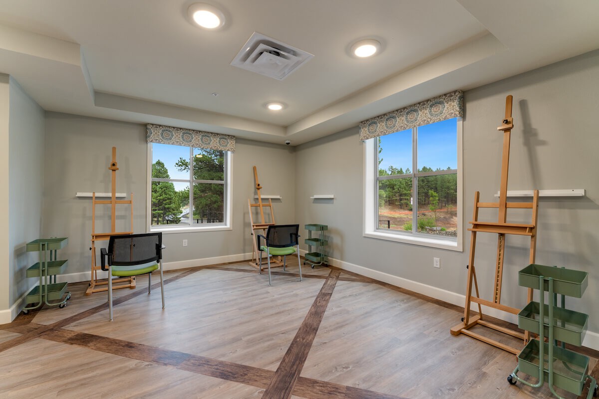 A bright art studio with easels and large windows providing ample natural light.