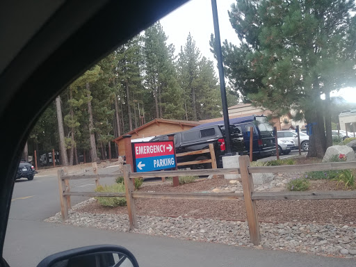 A view of a parking area with signage in a wooded setting.
