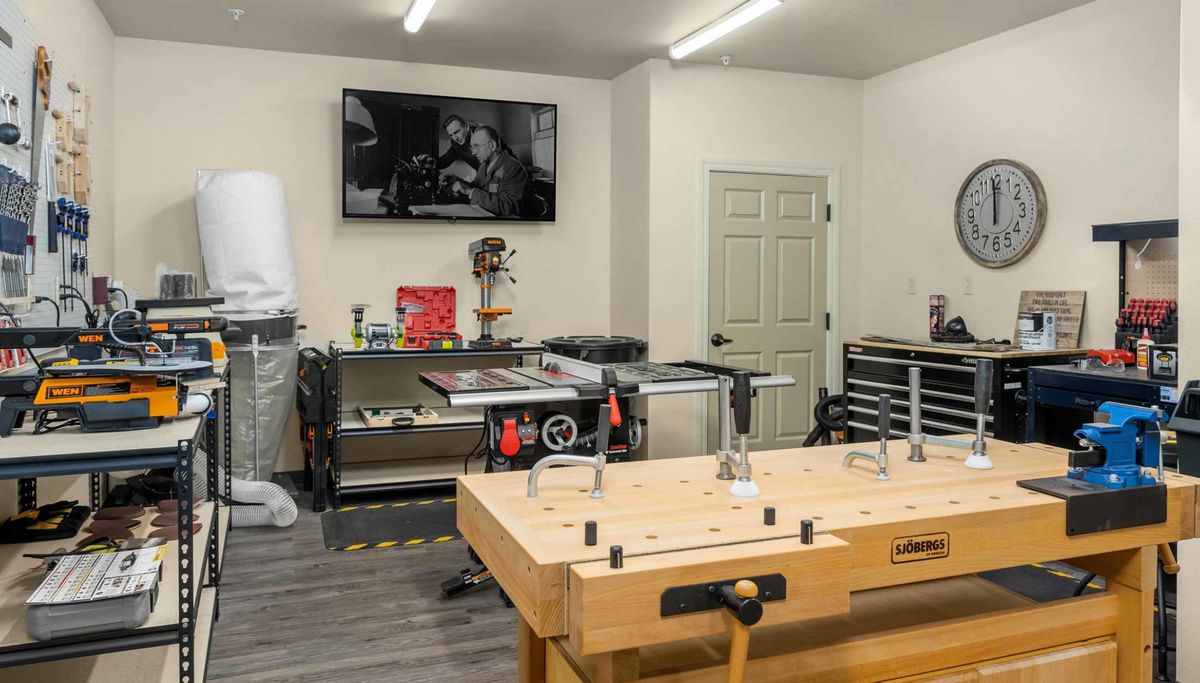 A well-organized woodworking workshop with a large bench and various tools.