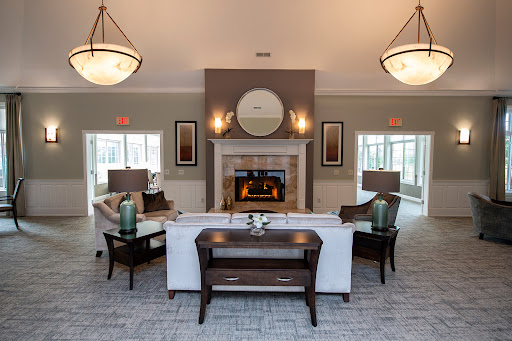 A modern and inviting living room featuring a fireplace, stylish furniture, and warm lighting.
