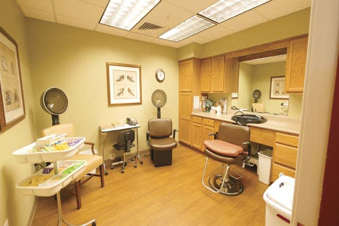 A small clinic room with chairs, a desk, and medical equipment.