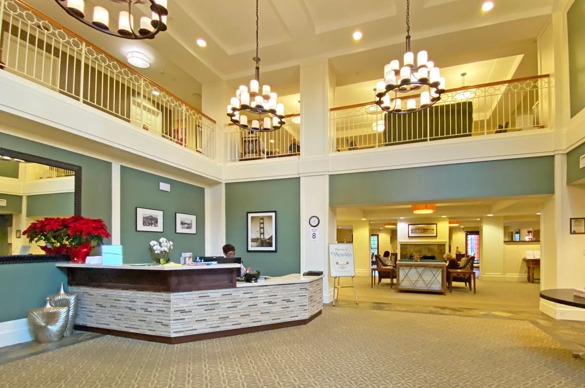 A spacious and elegantly designed lobby with chandeliers and a reception desk.