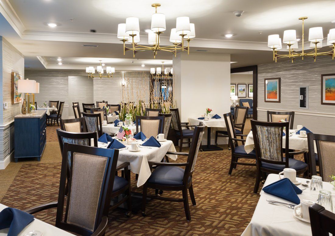An elegant dining area with neatly arranged tables and chairs, featuring stylish lighting and decor.