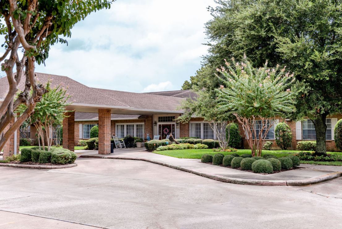 A suburban house with a well-maintained driveway and surrounding greenery.