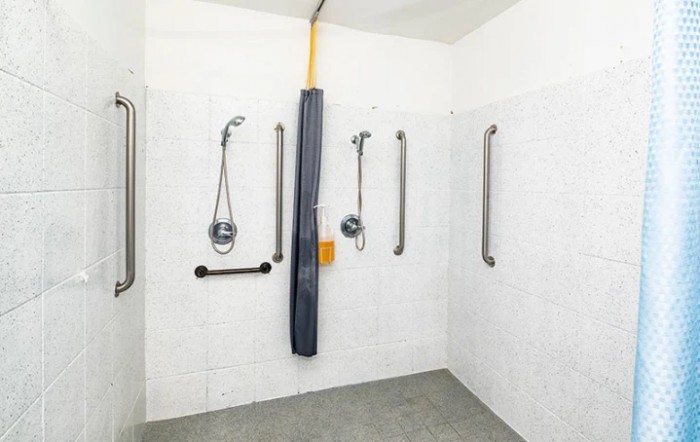 An accessible shower with multiple grab bars for safety.