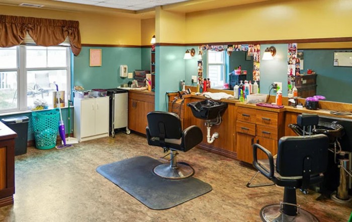 An empty barber shop interior with styling chairs and mirrors.
