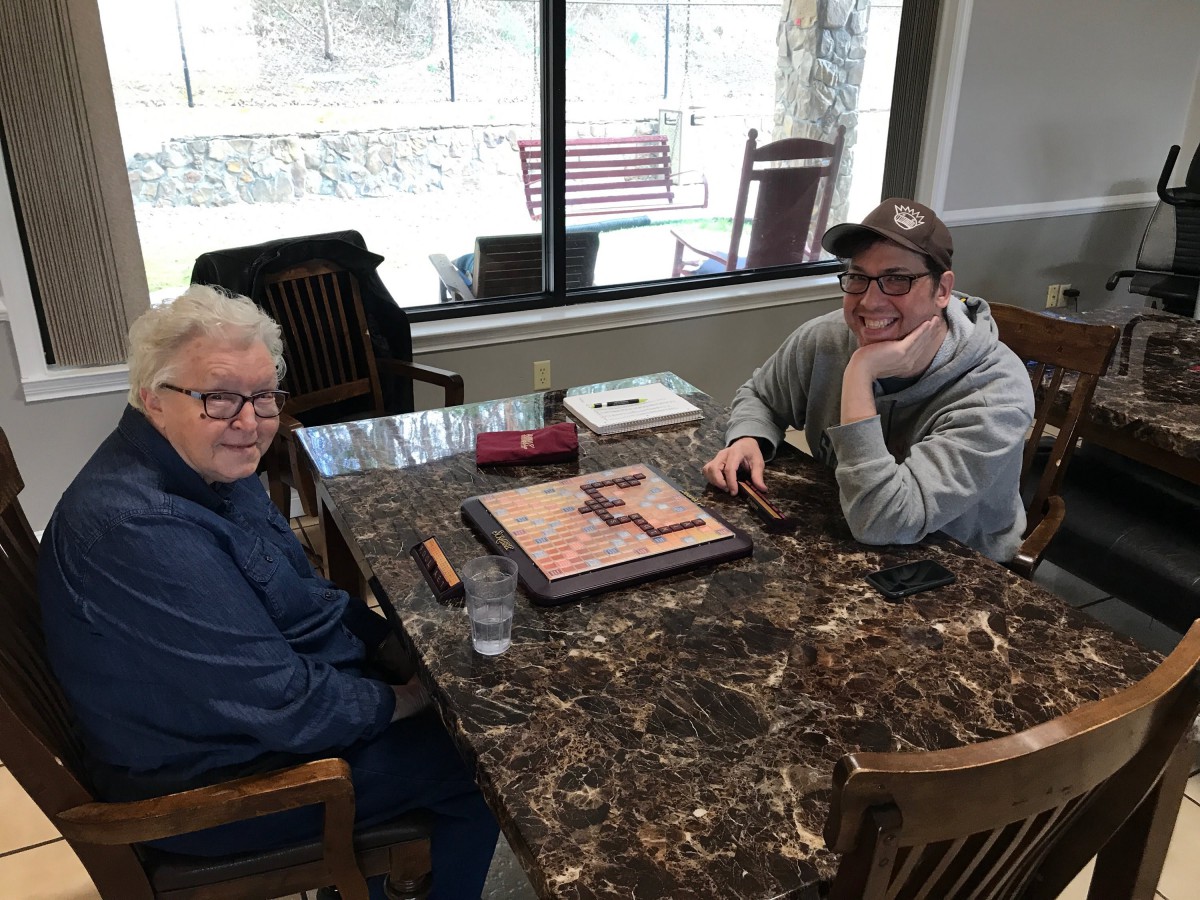 Two people sitting at a table working on a puzzle.