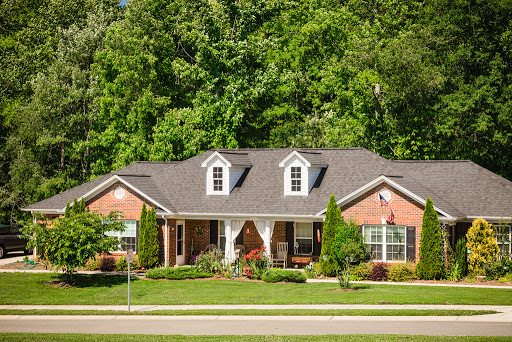 A charming brick house surrounded by lush greenery.