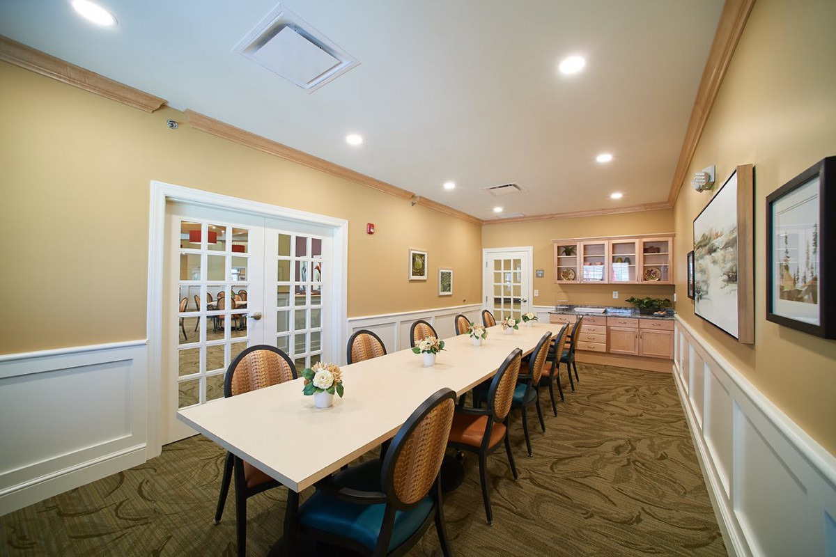 A modern conference room with a long table and chairs, featuring stylish interior design.