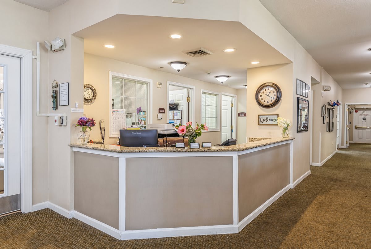 A welcoming reception area with a desk, flowers, and modern lighting.