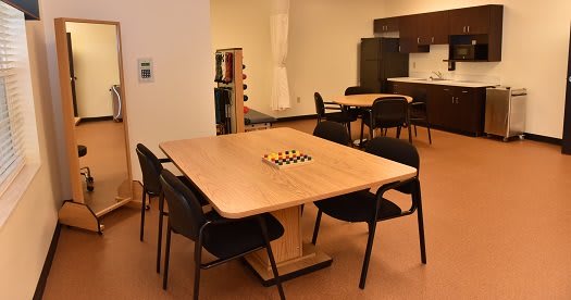 A cozy kitchen area with tables and chairs, featuring a chessboard centerpiece.