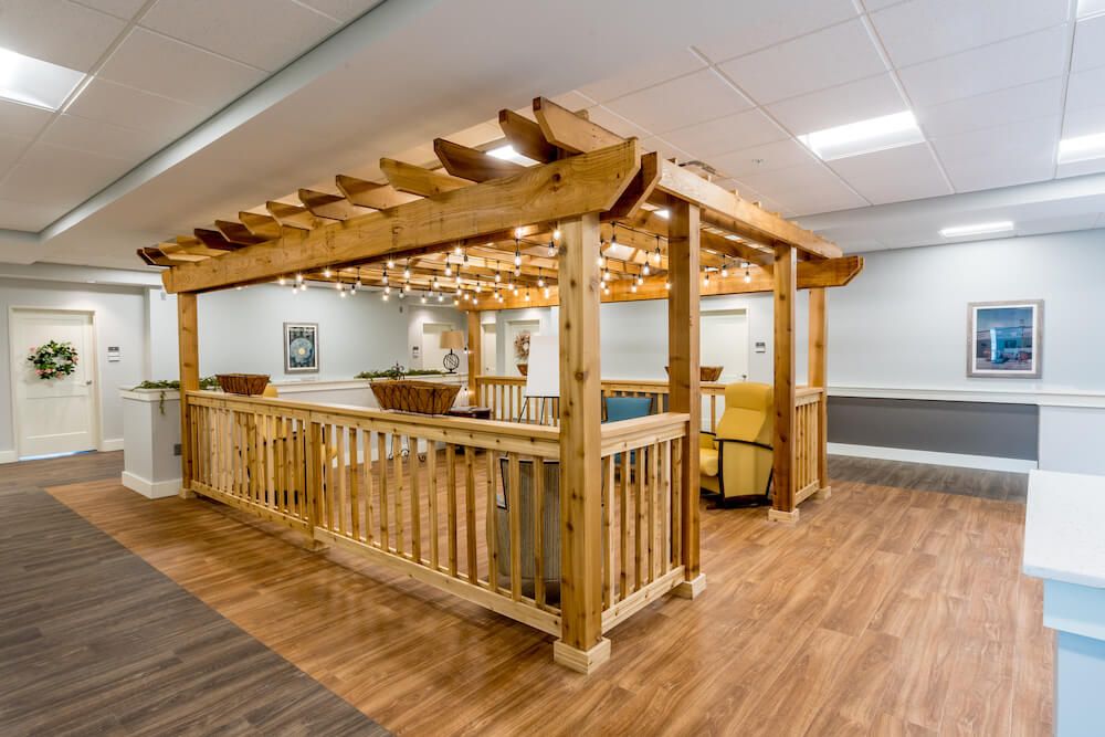 A wooden indoor pergola with seating and decorative lights.