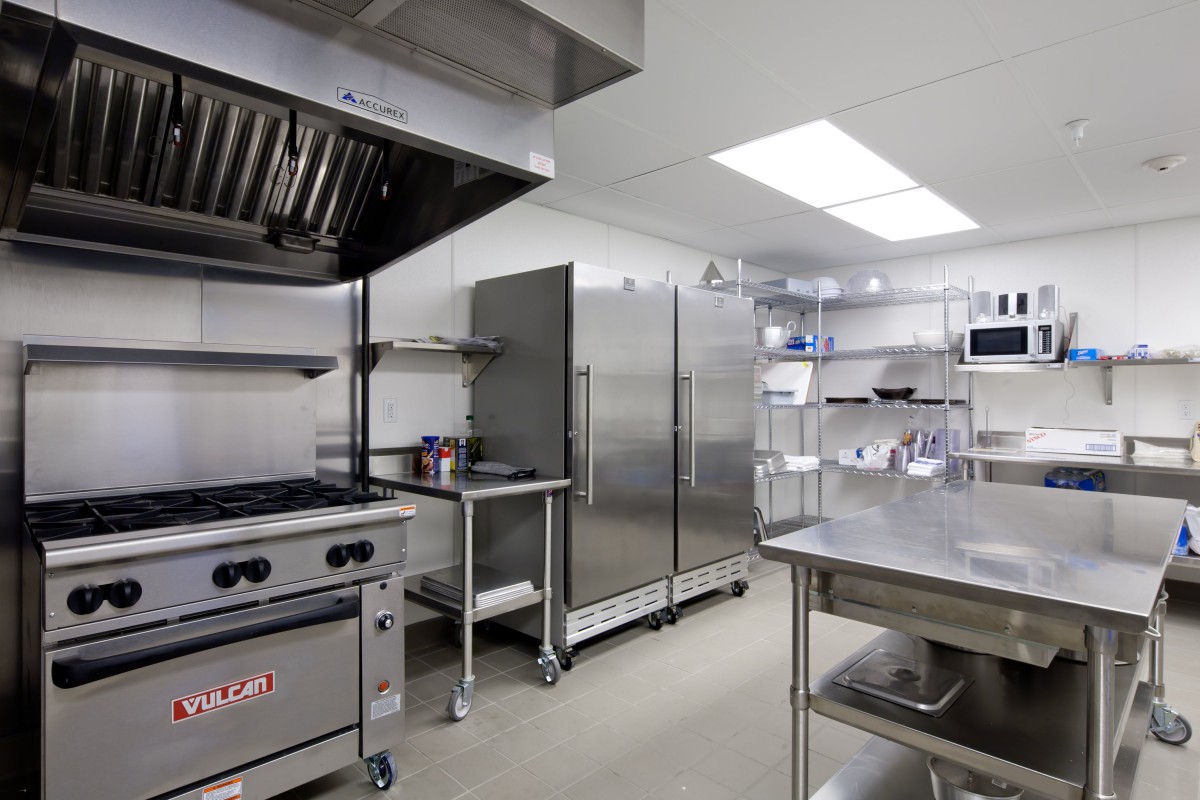 A clean and modern commercial kitchen with stainless steel appliances and ample preparation space.