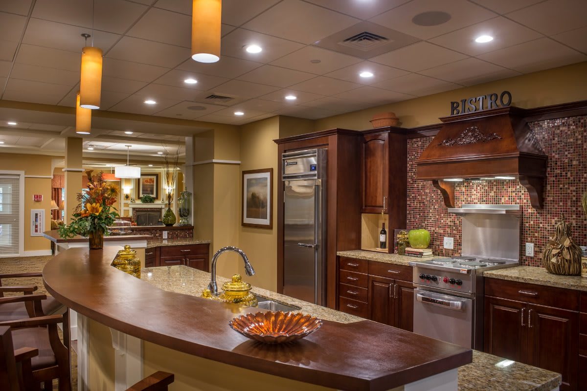A modern kitchen with wooden cabinetry, stainless steel appliances, and elegant lighting.
