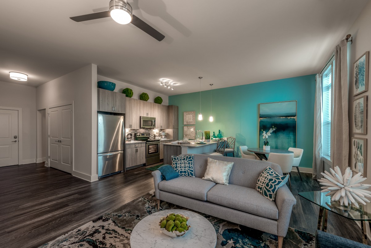 A modern open-plan living space featuring a sleek kitchen, cozy living room, and dining area with contemporary decor.