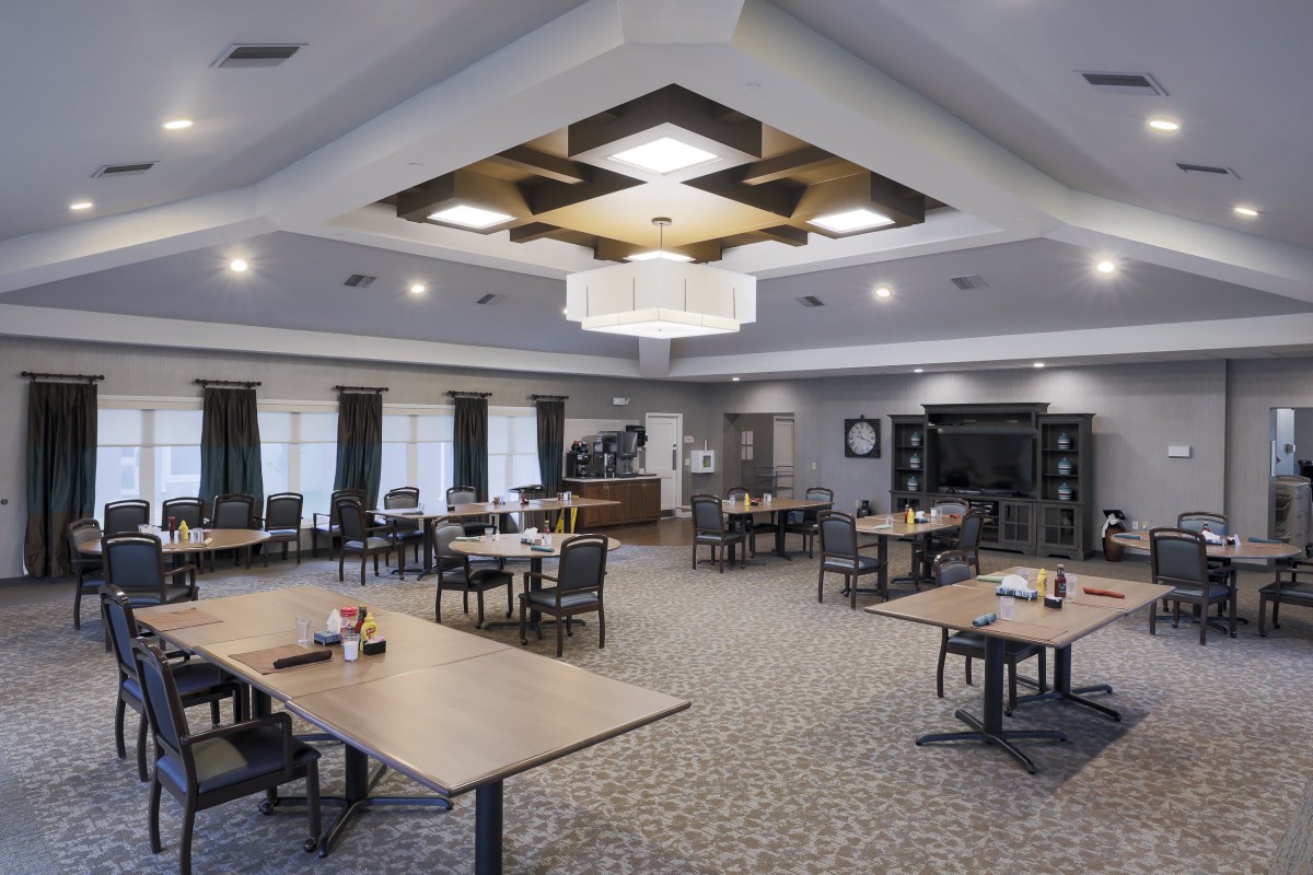 A modern conference room with tables and chairs arranged for a meeting.