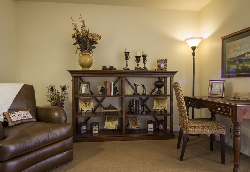 A cozy living room with a decorative bookshelf, floor lamp, and comfortable seating.