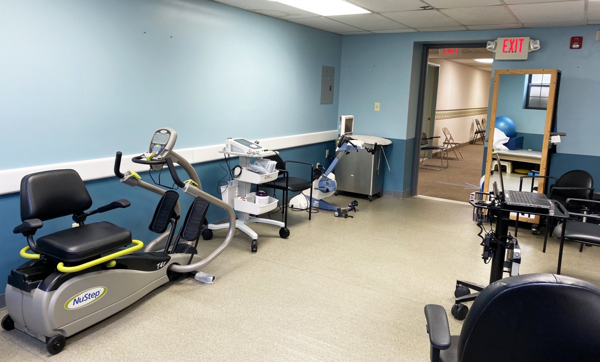 A room equipped with various exercise machines for rehabilitation and fitness.
