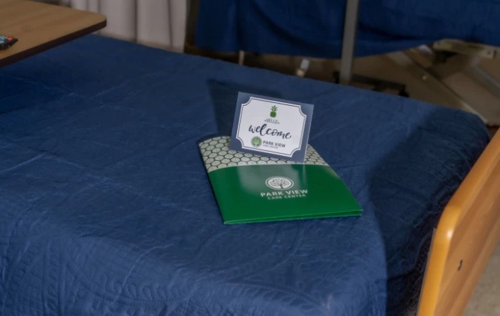 A welcome card and brochure placed on a blue-covered table.