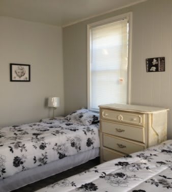 A cozy bedroom with twin beds and a dresser.