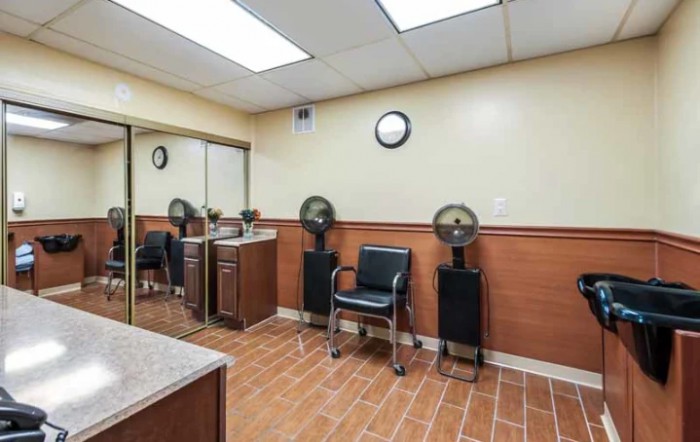 An interior view of a salon waiting area with styling chairs and fans.