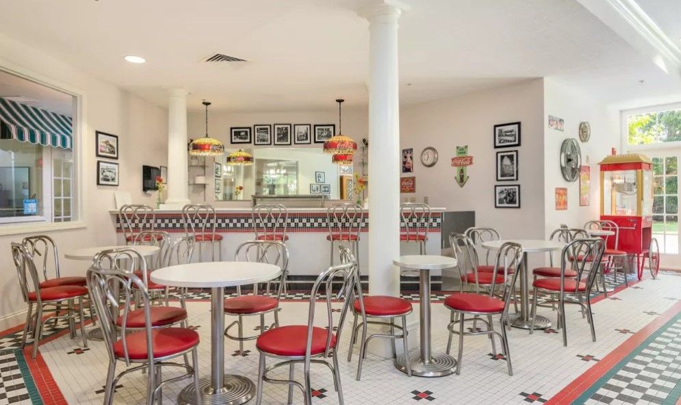 A retro-style diner with red chairs and tables, featuring classic decor.