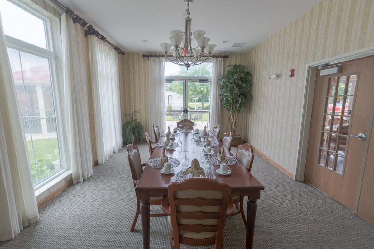A formal dining room with an elegantly set table and a chandelier.