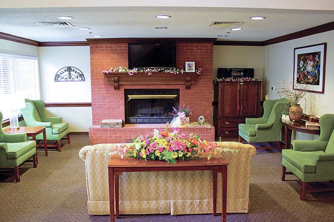 A cozy living room with a brick fireplace, television, and comfortable seating.
