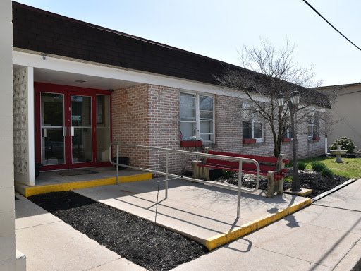 A view of a building entrance featuring an accessibility ramp.