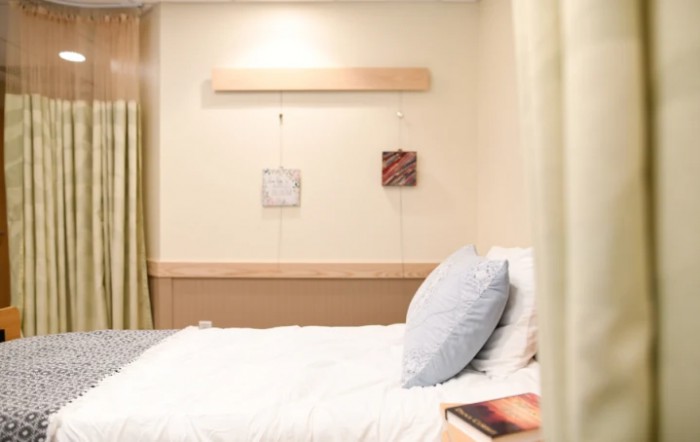 A minimalist bedroom with a neatly made bed and simple decor.